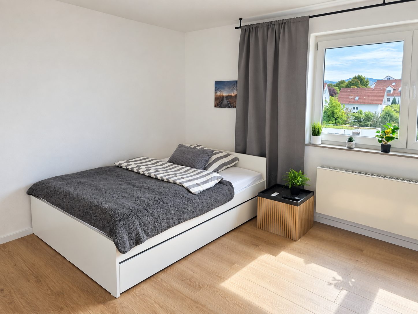 Lit avec matelas, oreiller et couette dans la chambre 3 — avec tiroirs de rangement sous le lit